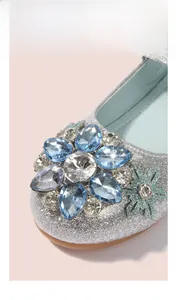 Detail von blauem Strass-Blume und Schneeflocke auf silbernen Prinzessinnen-Schuhen