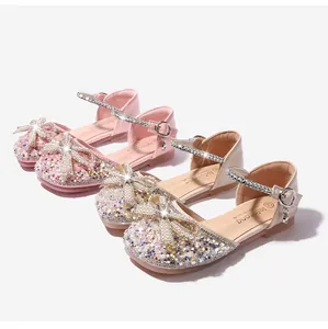 Detalle de zapatos de princesa para niñas con lentejuelas brillantes y lazos de perlas