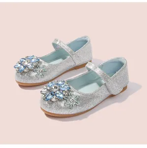 Detail der silbernen Glitzerschuhe mit blauen Juwelenblumen und Schneeflocken-Anhänger