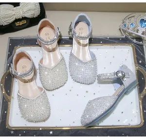 Close-up of girls princess sandals with sparkling rhinestones and pearls decoration