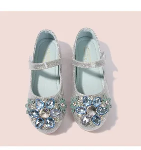 Detailaufnahme der blauen Kristallblume auf glitzernden silbernen Prinzessinnen-Schuhen