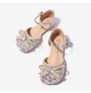 Detalle de sandalias brillantes para niñas con lazo de perlas y lentejuelas suaves