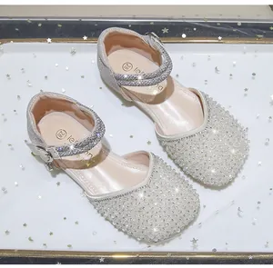Close-up of girls silver princess shoes featuring sparkling pearls and rhinestones detail