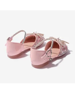 Detalle de lentejuelas rosas, perlas y lazo de cristal en zapatos de princesa para niñas