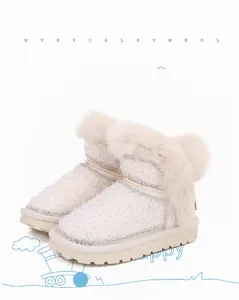 Dettaglio di stivali da neve bianchi perlati per bambina con paillettes e bordo in ecopelliccia