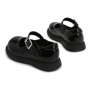 Detalle de zapatos Mary Jane de charol negro con hebilla plateada y suelas de goma gruesas