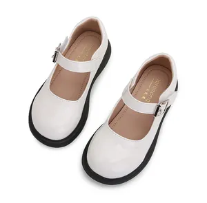 Primer plano de zapatos Mary Jane de charol blanco con suelas negras y hebillas de metal