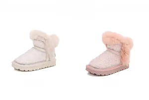 Dettaglio di stivali invernali luccicanti per bambini con bordo in pelliccia rosa e beige