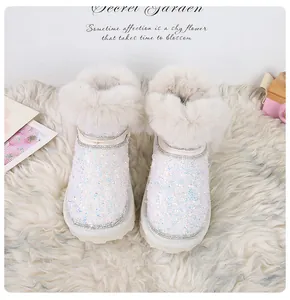 Dettaglio di stivali da neve glitterati con bordo in ecopelliccia e paillettes lucide