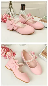 Detail of pink Mary Jane shoes with bow and pearl strap on marble background