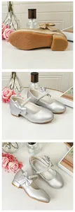 Detail view of anti-slip soles and pearl bow accents on girls' princess dress shoes
