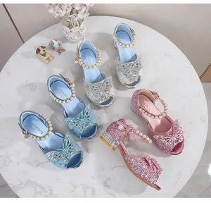 Macro shot of glitter princess high heel sandals with crystal bows and pearl straps