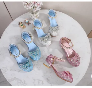 Close-up of glitter Mary Jane shoes with rhinestone bows and pearl straps for girls