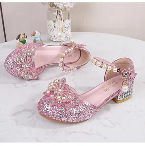 Macro view of pink sequin girl shoes with rhinestone bow and pearl strap detail