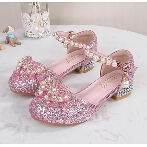 Close-up of pink sequin girl's princess shoes with rhinestone bow and pearl strap
