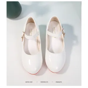 Dettaglio scarpe Mary Jane bianche da bambina in vernice con ciondolo dorato