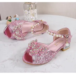 Detail of pink sequin girls' sandals with rhinestone bow and pearl ankle strap
