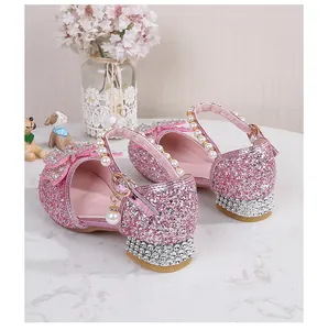 Close-up of pink glitter girls' princess shoes with rhinestones and pearl straps