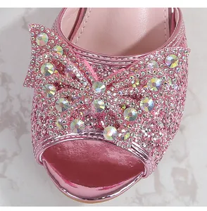 Close-up of pink sequin girls' sandals with large rhinestone bow and open-toe design