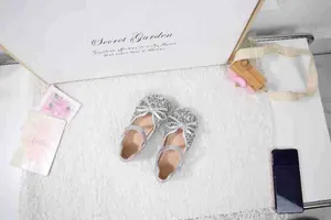 Detailaufnahme silberner Pailletten-Ballerinas für Mädchen mit Schleife und Riemen