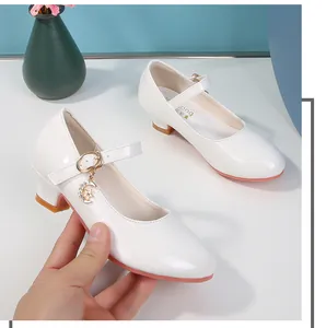 Dettaglio scarpe Mary Jane in vernice bianca per bambine con ciondoli a forma di luna