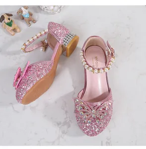 Detail of pink sequin girls' shoes with rhinestone bow and pearl ankle strap
