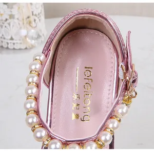 Close-up of pink girls' princess shoes with large white pearls and sparkling rhinestone details