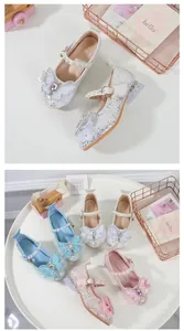 Detailansicht der glitzernden Mary Jane Prinzessinnenschuhe mit Perlenriemen und Schleife