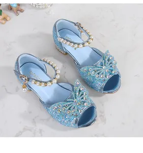 Detail of blue glitter sandals with rhinestone bow and pearl strap for girls