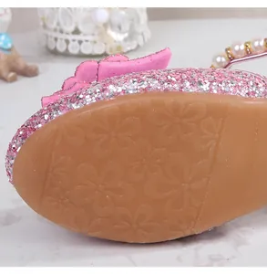 Detailed view of the pink glittered girl's shoes featuring non-slip floral rubber soles