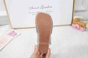 Detail der Gummisohle mit herzförmigem Antirutschprofil und silbernen Pailletten bei Mädchenschuh