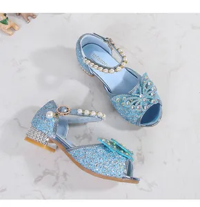 Macro detail of blue sequin princess shoes with rhinestone bow and pearl ankle strap