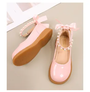 Detail van roze Mary Jane schoenen met parelbandje en een zijden strik voor meisjes