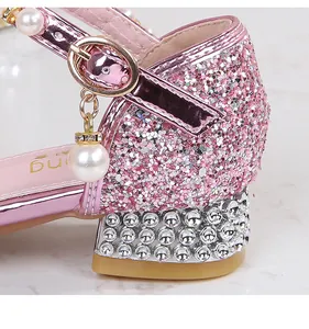 Close-up of pink glitter girls' princess shoes featuring rhinestone heels and pearl charms