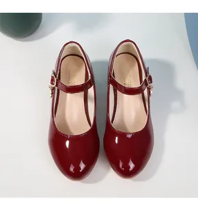 Dettagli scarpe Mary Jane in vernice bordeaux con fibbia dorata e finitura ultra lucida