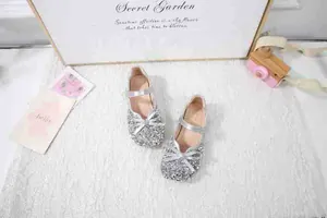 Detailansicht der silbernen Glitzer-Mary-Jane-Schuhe mit Doppelschleife und Riemen