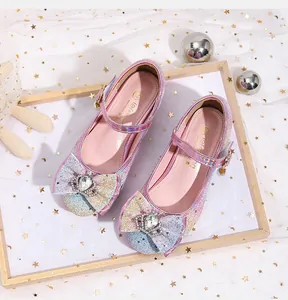 Close-up of pink glitter girls' Mary Jane shoes with crown rhinestone bow and velcro strap
