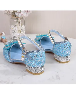 Detail of light blue glitter princess shoes with pearl straps and rhinestone heels