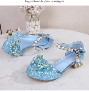 Close-up of light blue sequined girl's princess shoe with diamond bow and pearl strap