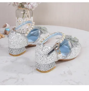 Detailed close-up of girls silver sequin princess shoes with rhinestone heels and pearl charms