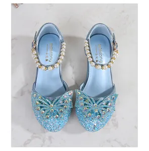 Detail of light blue glitter princess shoes with rhinestone butterfly and pearl strap