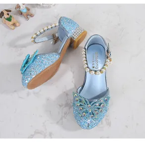Detail of light blue sequined princess shoes with rhinestone bow and pearl strap