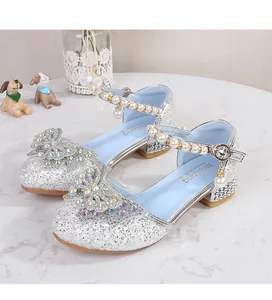 Detail of silver sequin Mary Jane shoes featuring a colorful rhinestone bow and pearls