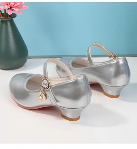 Dettaglio di scarpe Mary Jane argento con glitter e ciondoli a luna e stella sui cinturini