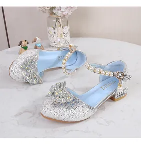 Detail of silver sequined girls shoes with sparkling bow and pearl ankle strap