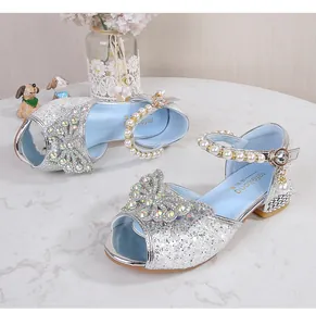 Detail of silver glitter girls princess shoes with rhinestone bow and pearl strap