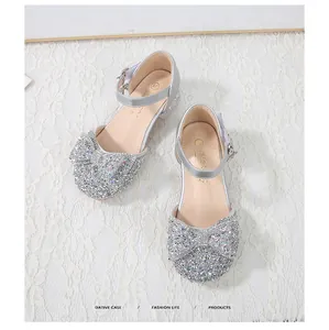 Close-up of sparkling silver girl's princess shoes with sequins and rhinestone bow detail