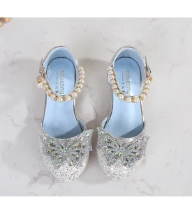 Detail of silver sequined Mary Jane shoes with rhinestone bow and pearl strap