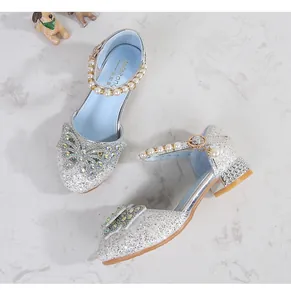 Close-up of sparkling silver glitter girls princess shoes with pearl straps and rhinestones