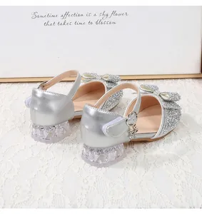 Detail of silver sequin girls princess shoes with bow ornament and crystal square heel